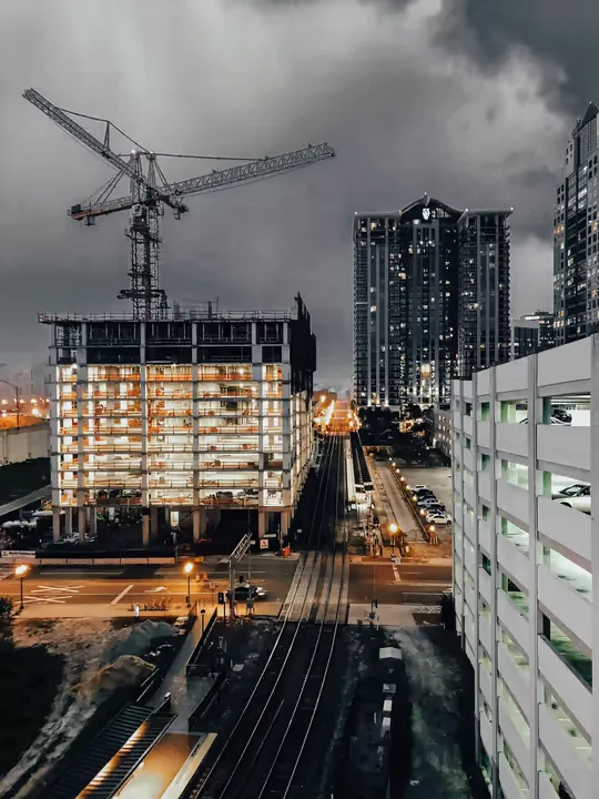 Urban construction tower coordinated beside completed buildings.